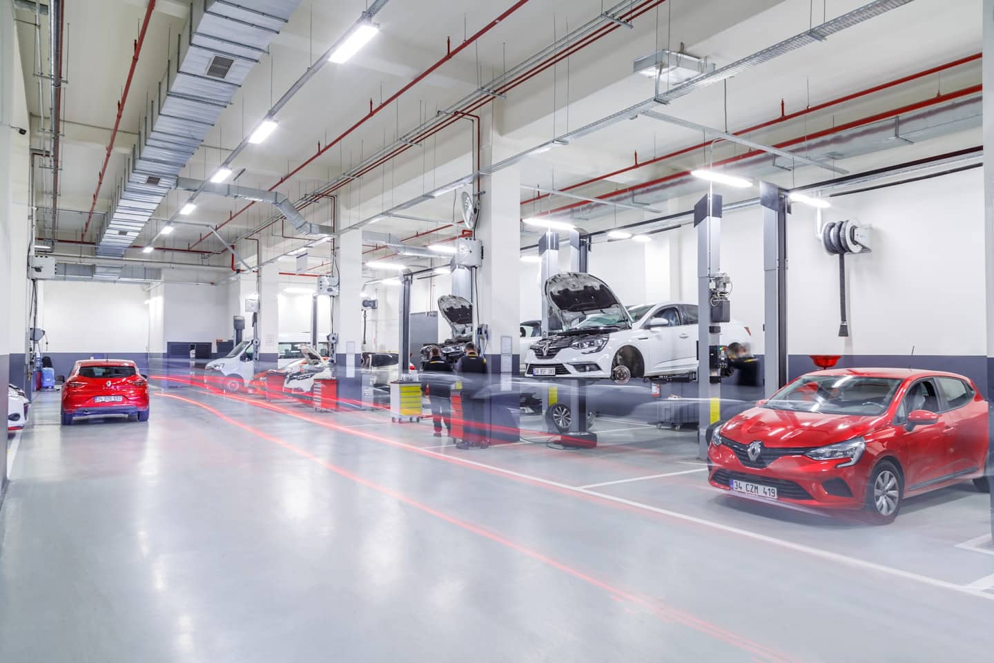 Mechanici provádějí údržbu automobilů v profesionální servisní dílně.